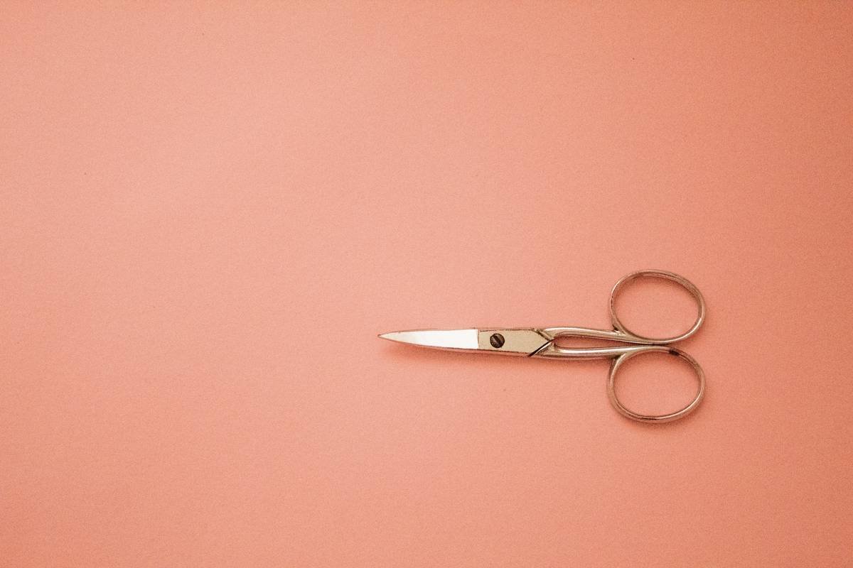 Diagram showing aligned vs misaligned beard scissors: aligned blades meet edge-to-edge; misaligned blades show gap at tips causing hair bending