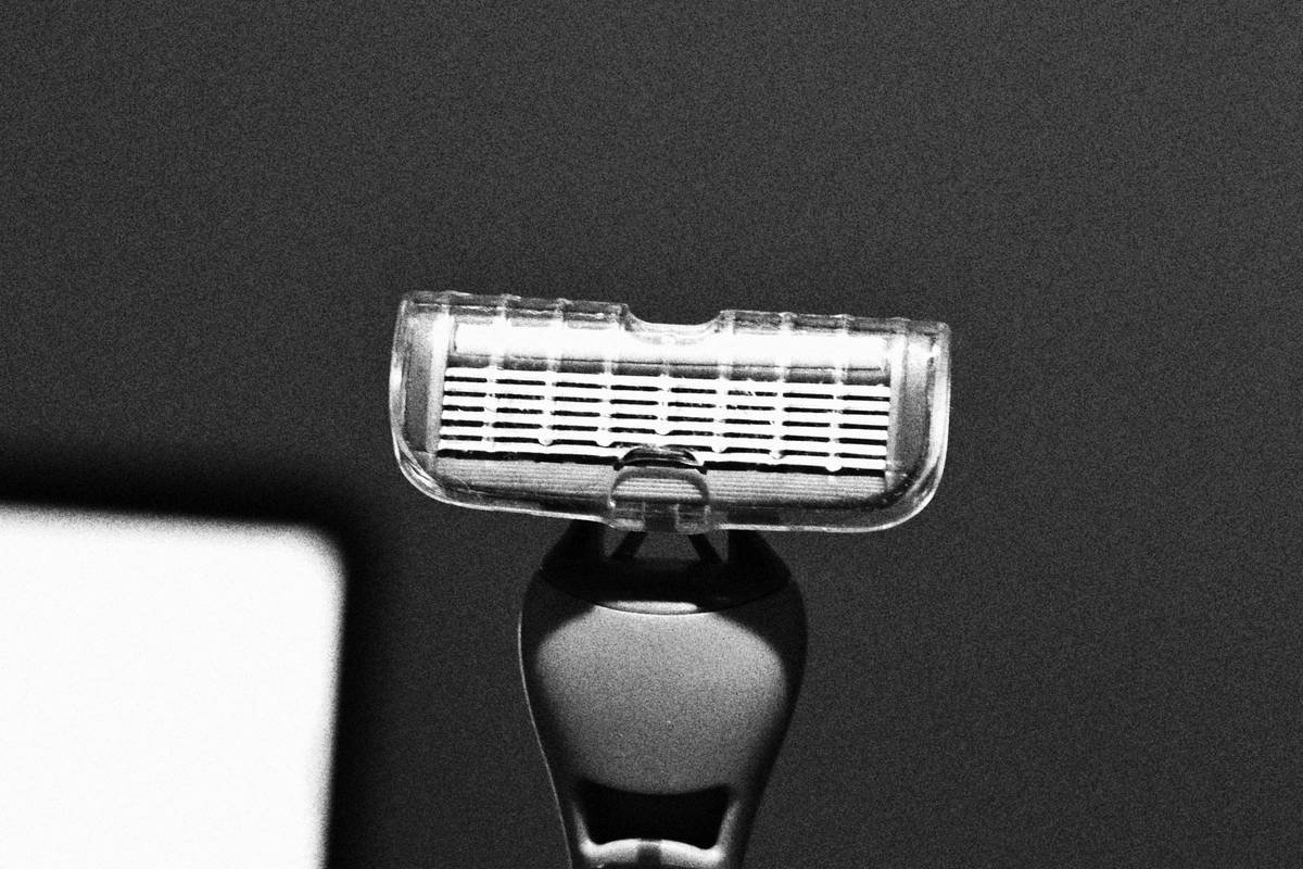 Close-up of applying blade lubrication to high-end beard scissors at the pivot point